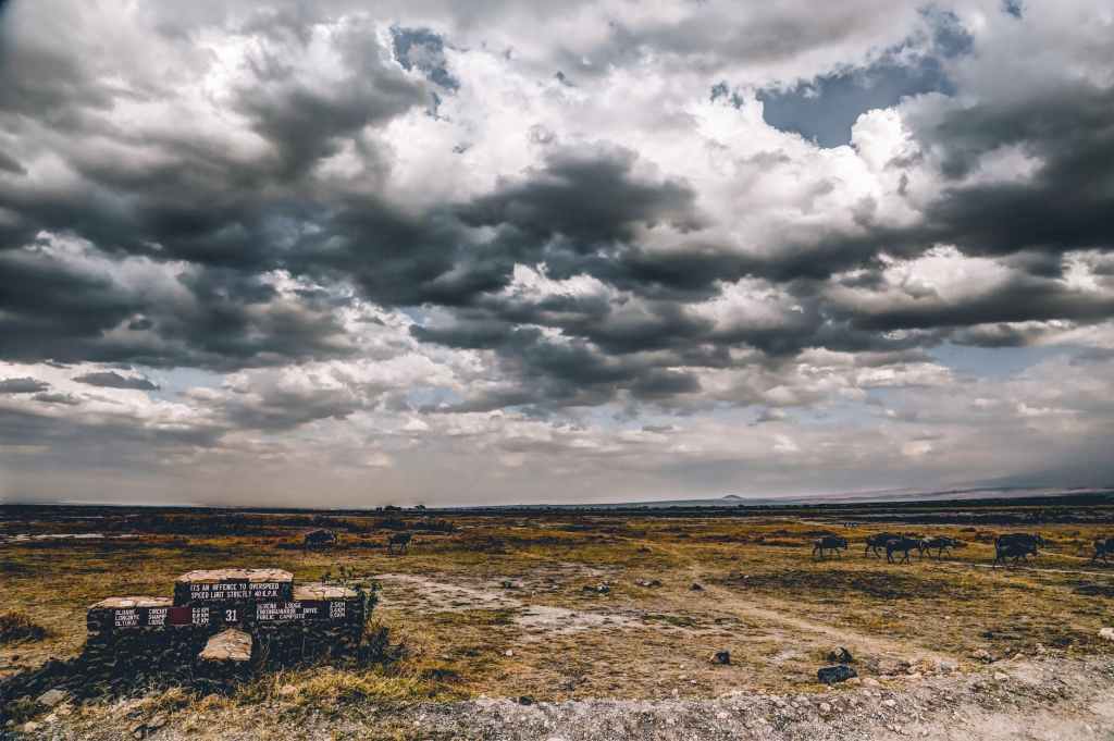 Image with dark clouds over flat land and 1 lone building