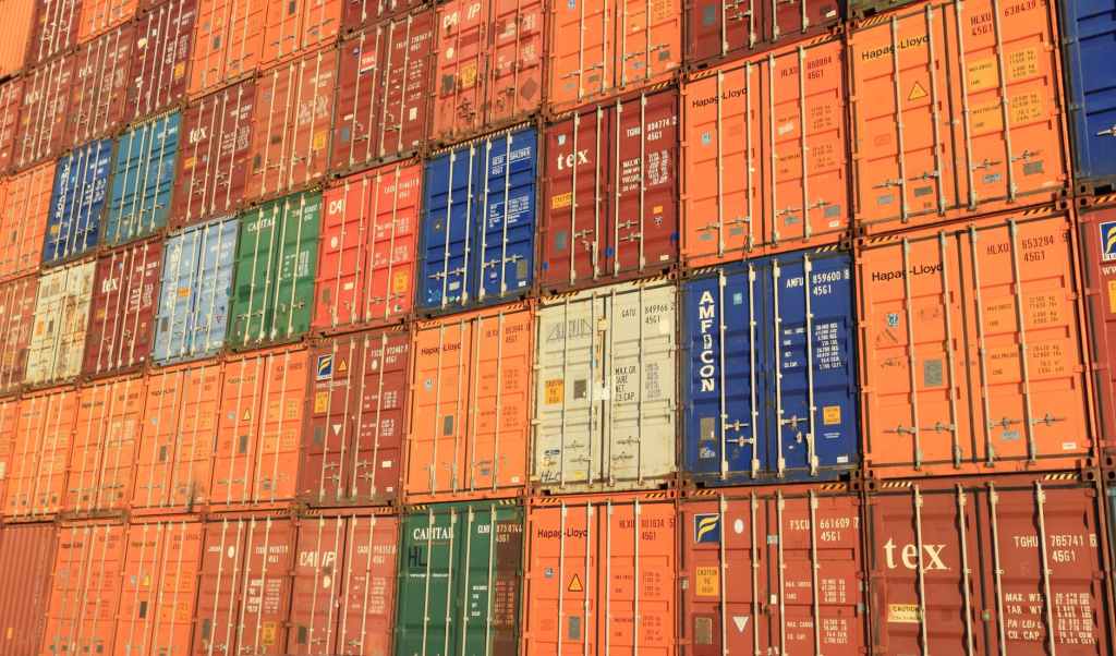 rows and rows of colorful cargo shipping containers - orange, blue, green, grey