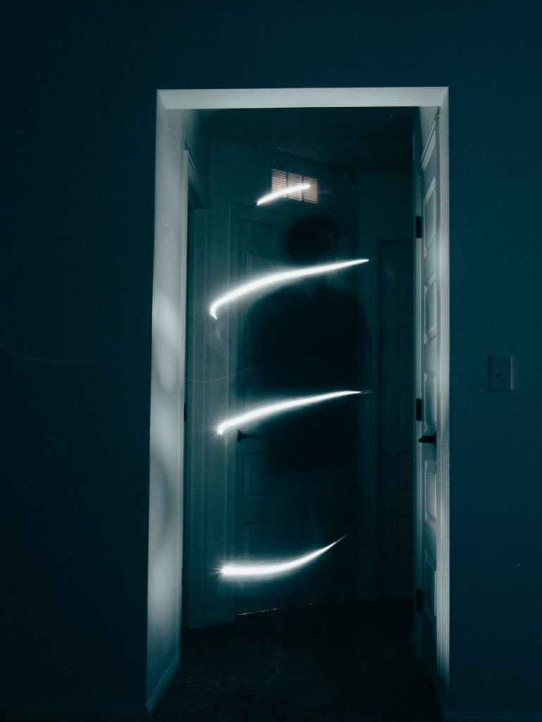 a black door with slits of light sowing thru