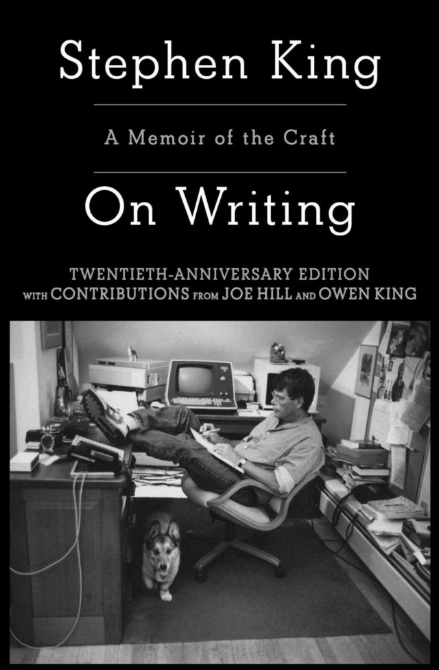 stephen king at his desk with his dog close at his feet